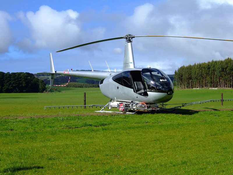 grey helicopter parked in field